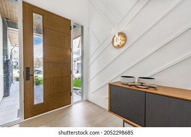 Entry hall and foyer with glass walls stairs console table bench and wooden door - Shutterstock ID 2052298685