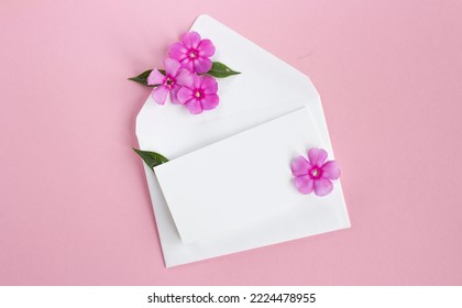 Envelope With Flowers. Beautiful Flowers In A Mail Envelope On A White Background. Greeting Card For The Holiday.  Copy Space