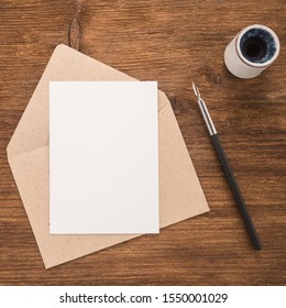 Envelope, ink pen, inkwell on wood table - Shutterstock ID 1550001029