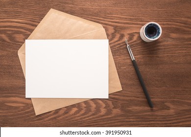 Envelope, ink pen, inkwell on a wooden background 
 - Shutterstock ID 391950931