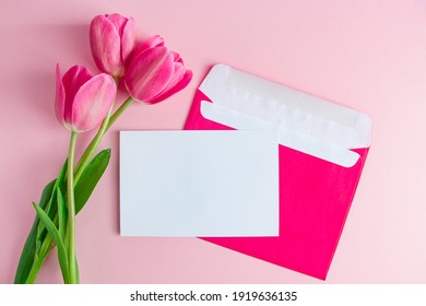 Envelope With Invitation To Holiday And  Bouquet Of Tulips On Pink Background. Place For Text.