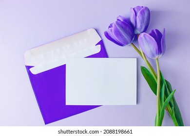 Envelope With Invitation To Holiday And Bouquet Of Tulips On Purple Background. Trendy Color Of The Year 2022. Place For Text.