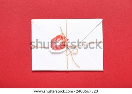 Envelope with lipstick kiss mark on color background. Valentine's Day celebration