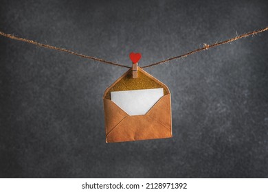 envelope with message hanging on rope with clothespin in the form of heart on gray background. valentine's day. copy space - Powered by Shutterstock