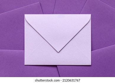Envelope on pile of envelopes. Gift envelope purple color for congratulation. Gift certificate