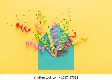 Envelope With Party Confetti Explosion On Yellow Background. Invitation Card, Flat Lay.