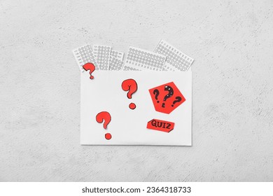 Envelope with quiz forms and question marks on white background