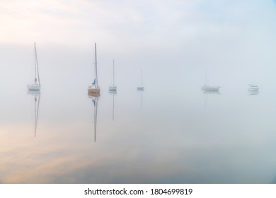 Enveloped in a dense fog boats appear through the mist over the bay. Koolewong on the Central Coast, NSW, Australia.