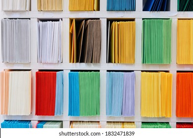 Envelopes stacks sorted on a shelf by color. Colorful mail wraps arranged in categories. - Shutterstock ID 1832471839