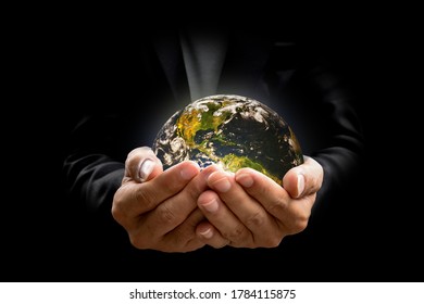 Environment concept. Earth in hands on black background. Elements of this image furnished by NASA - Shutterstock ID 1784115875