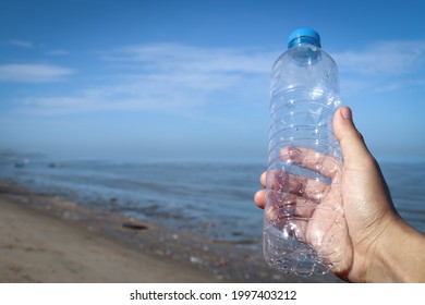 Environment, Ecology Care, Renewable Concept. Hand Keep Cleanup The Plastic Bottle On Beach.