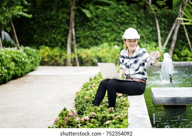 Environment Engineer, Confident Young Asain Woman Engineer Wearing White Hardhat Helmet With Laptop Checking The Water Quality From Water Pond.
