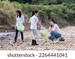Environment and pollution caring management concept, group of Asian friends collect dirty plastic bottles in the stream for recycling, volunteer kids family pick up garbage and wastrel from tourist 