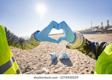 Environmental activist volunteers making heart with hands. People with gloves picking up plastic garbage on beach sunny day. Protection and care of planet earth and its ecosystems. - Powered by Shutterstock