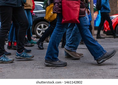 Environmental Activists March In City. Many Legs Are Viewed Marching In A Town Center As Environmentalists Demonstrate Together, Bustling Street Scene During A Community Protest.