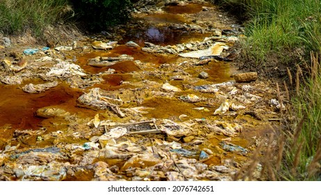 Environmental Disaster. The Polluted Small Local River Is Located Next To The Massive Mining Site In Serbia. Ecology Problem Caused By Metallurgical Industry. 