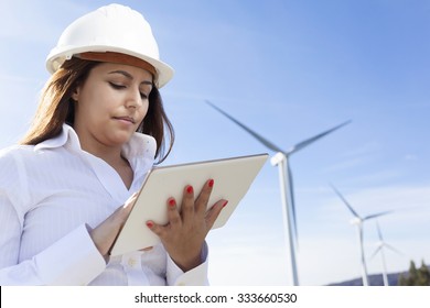 Environmental engineer with a tablet computer at wind farm