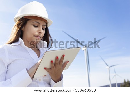 Environmental engineer with a tablet computer at wind farm
