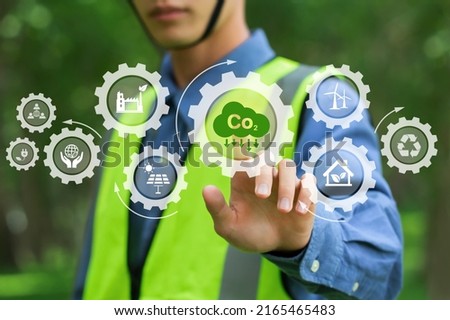 environmental engineering touching green CO2 icon and green icon on a green background. Renewable energy-based green businesses can limit climate change and global warming. Reduce CO2 emission.