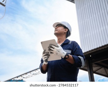 Environmental engineers checking continuous emission monitoring system at industrial plant for sustainable future environment, air pollution reduction. Technician use digital tablet standing exhaust 