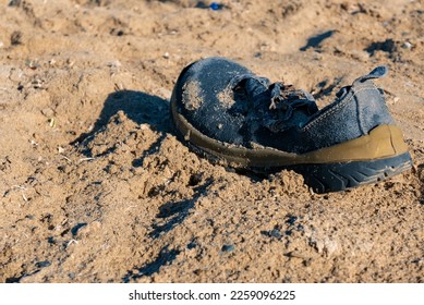 Environmental pollution. A old, battered shoe washed up on the seashore. Red Sea, Egipt Africa - Shutterstock ID 2259096225