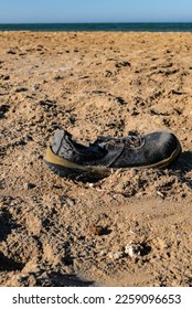 Environmental pollution. A old, battered shoe washed up on the seashore. Red Sea, Egipt Africa - Shutterstock ID 2259096653