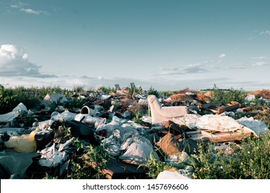 Environmental Pollution. View Of The Field Spoiled By Debris And Plastic. The Issue Of Environmental Disaster