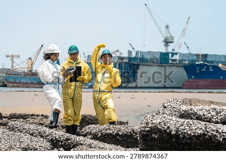 Environmental workers in protective biohazard suits monitoring toxic industrial wastewater and hazardous pollution contamination outdoors.