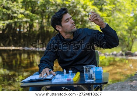 The environmentalist is testing a water Stream in the forest. Environment, science.