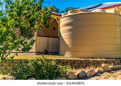 Environmentally friendly above-ground water tank installed to harvest rainwater from the roof of a rural house. It provides a renewable supply of water for household use.