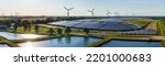 Environmentally friendly installation of photovoltaic power plant and wind turbine farm situated by landfill.Solar panels farm  built on a waste dump and wind turbine farm. Renewable energy source.