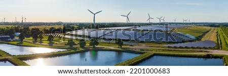 Environmentally friendly installation of photovoltaic power plant and wind turbine farm situated by landfill.Solar panels farm  built on a waste dump and wind turbine farm. Renewable energy source.