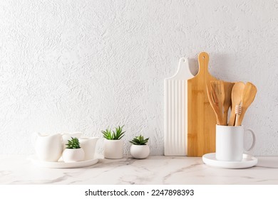 environmentally friendly items of modern tableware on a white marble countertop with green plants in mini-hills. space for text. minimalist style - Shutterstock ID 2247898393