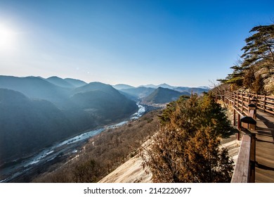 Eochi-ri, Sunchang-gun, Jeollabuk-do, South Korea - January 31, 2022: Aerial and winter view of hiking deck trail at Yonggol Mountain against Seomjingang River in the background
