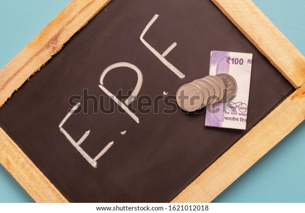 EPF or Employee provident Fund written on black slate with Indian Currency notes and Coin