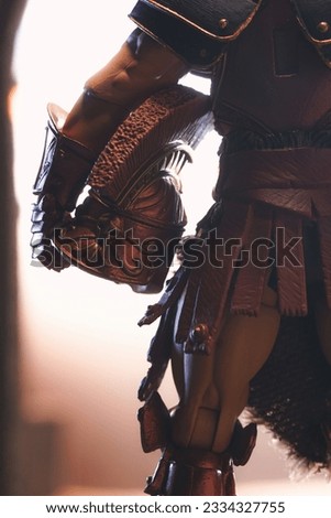 An epic action figure of a gladiator character holding his helmet by his hip with beautiful lighting