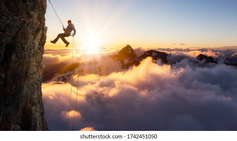 Epic Adventurous Extreme Sport Composite of Rock Climbing Man Rappelling from a Cliff. Mountain Landscape Background from British Columbia, Canada. Concept: Explore, Hike, Adventure, Lifestyle