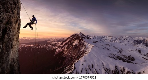 Epic Adventurous Extreme Sport Composite of Rock Climbing Man Rappelling from a Cliff. Mountain Landscape Background from British Columbia, Canada.