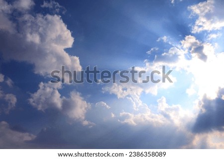 Epic beautiful sun rays breaking through trough the clouds on a blue afternoon sky.
