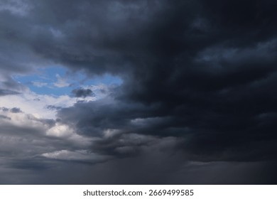 Epic Dramatic storm dark grey cumulus rain clouds with blue sky, background texture, thunderstorm