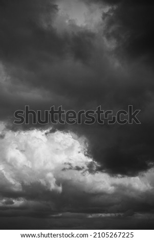 Epic Dramatic storm sky with dark grey black and white cumulus rainy clouds background texture. Black and white photo
