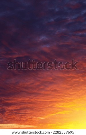 Epic dramatic sunset, sunrise on storm sky with dark clouds, orange yellow sun and sunlight
