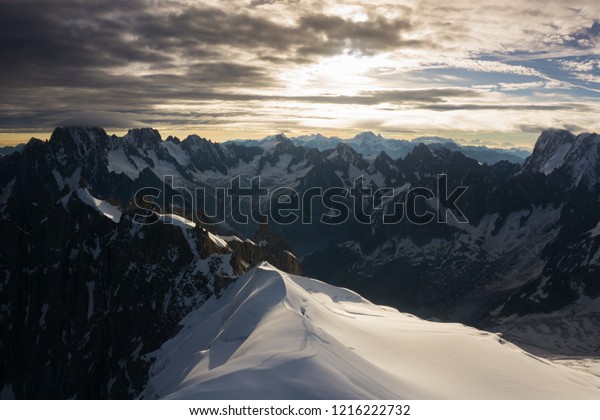 Epic landscape in Mont Blanc from Aiguille du Midi\
cable car station (Chamonix, France) in summer. Snow, glacier,\
mountain peaks and clouds