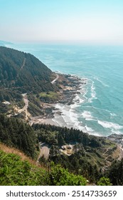 Epic panoramic summer view from top of Cape Perpetua Lookout Oregon, coastline and winding road on the cliff, rocky beach and hiking trails, , cloudy haze horizon ocean line