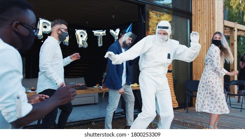 Epic Party Celebrating Return To Social Life After COVID-19, Multiethnic Friends Dance In Costumes And Masks Slow Motion