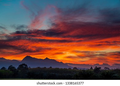 Epic red sunset in mountains. Empty grassland and sky at evening time. 