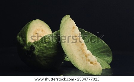 epic shot of a fresh green guava fruit slice closeup isolated on black background. fresh green guava closeup on black background
