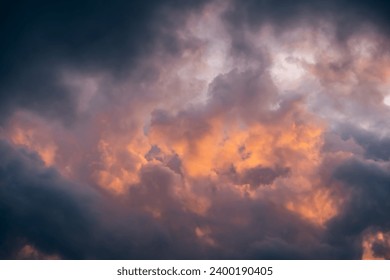 Epic sky at sunset. Dark dramatic sky clouds with orange sunlight holes. Storm weather. Beauty in nature. Twilight, golden hour. Thunderstorm. Evening sunset. Nature landscape. Panoramic view.