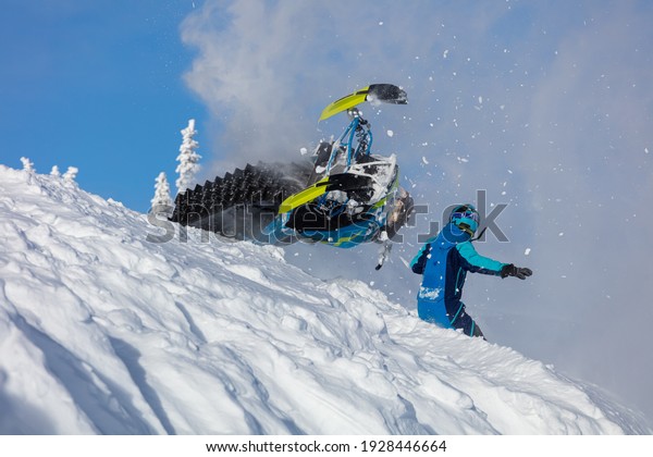 epic snowmobile fall.\
sports snowmobiles in the mountains. bright skidoo motorbike and\
suit without brands. Winter fun, snowmobilers sports riding. high\
resolution photos