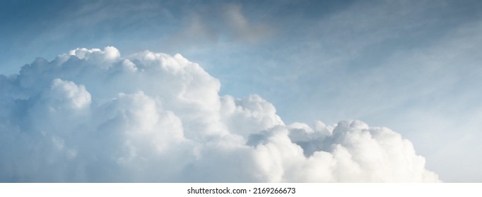 Epic storm cloudscape. White ornamental sunset cumulus clouds. Soft sunlight, sun rays. Clear blue sky. Natural pattern, texture, background, wallpaper, 3D, graphic resources, design, copy space